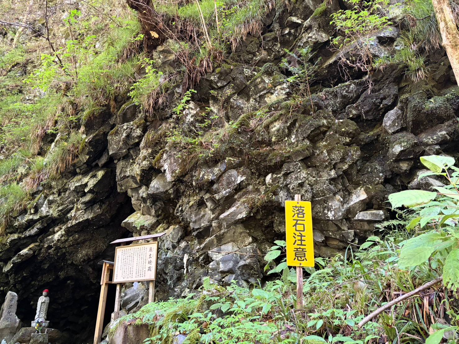 巌立地蔵と牛の鼻づらの洞穴。赤い頭巾のお地蔵様と溶岩の岩壁