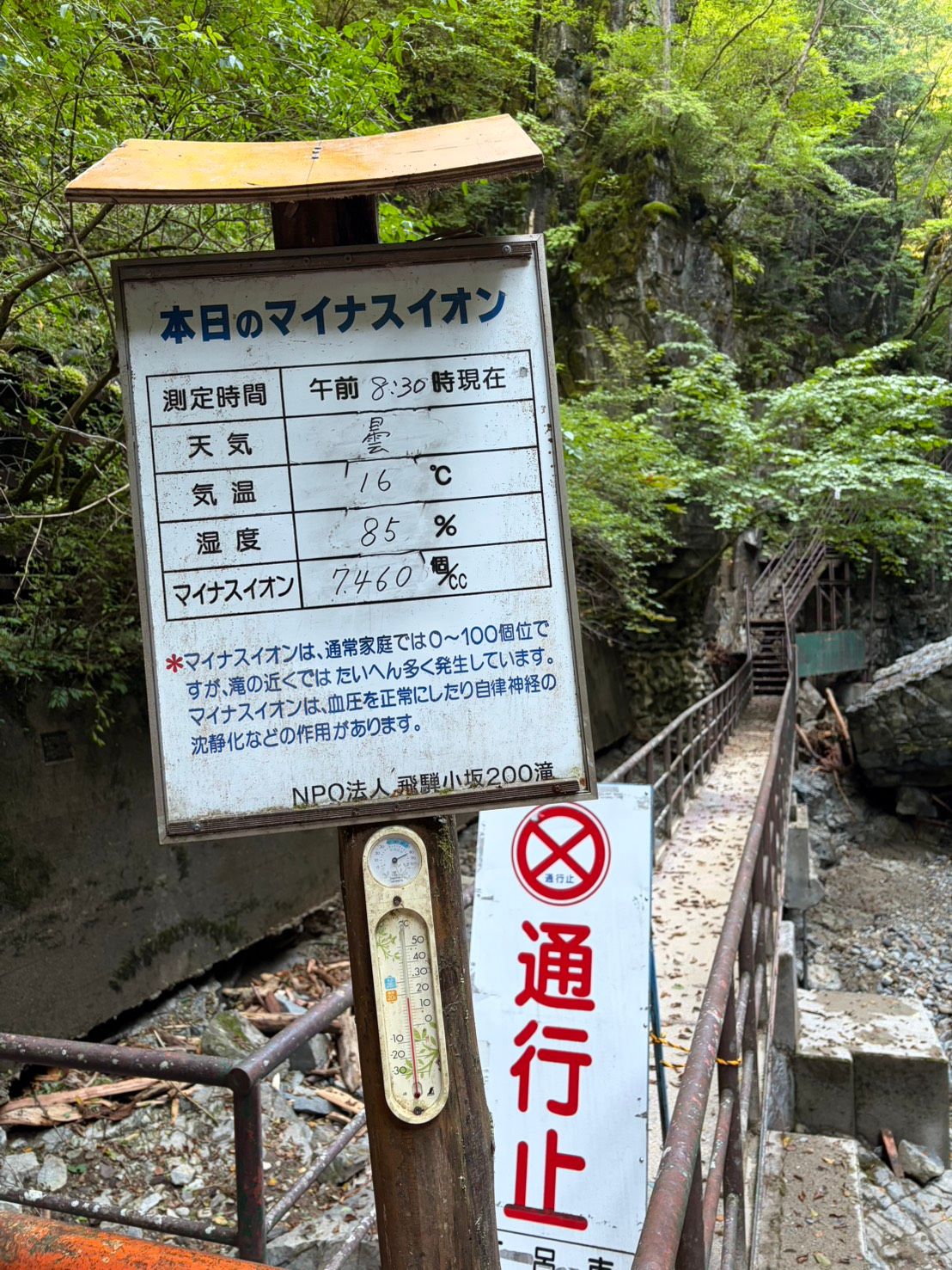 本日のマイナスイオンの手書き看板。7460個と書かれ、その下に通行止の看板が下がっている