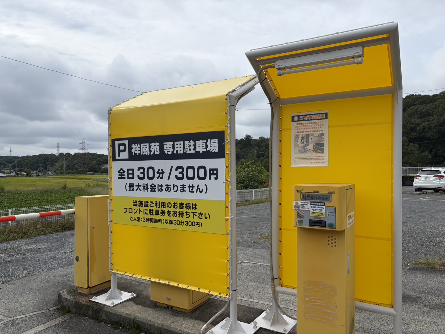祥風苑の駐車場の料金看板。全日30分300円で最大料金なし。入浴すると3時間無料