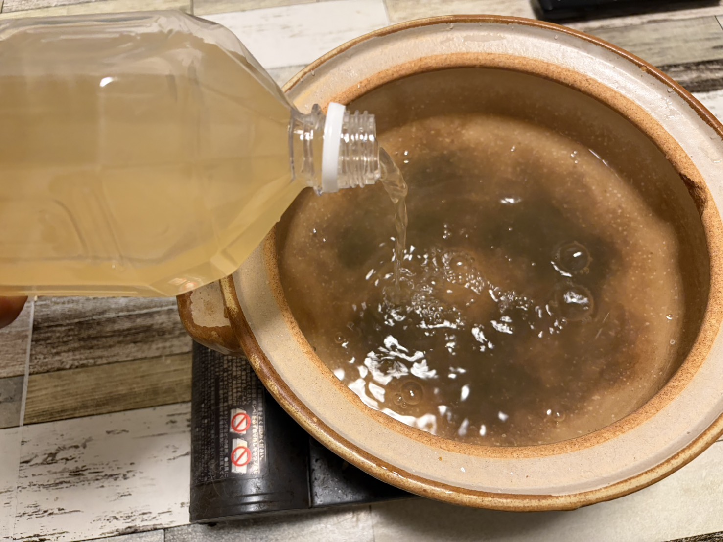 持ち帰った温泉水を土鍋に注いでいるところ。透明な湯