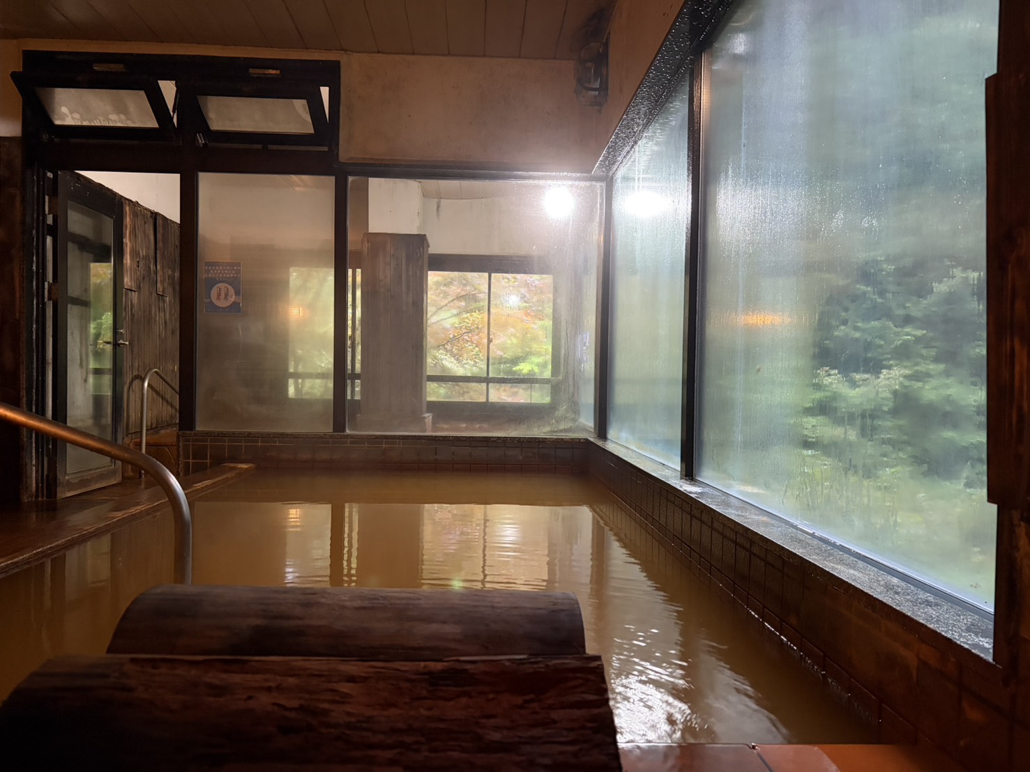 明治温泉のあつ湯。鉄褐色のお湯。奥にぬる湯が見える